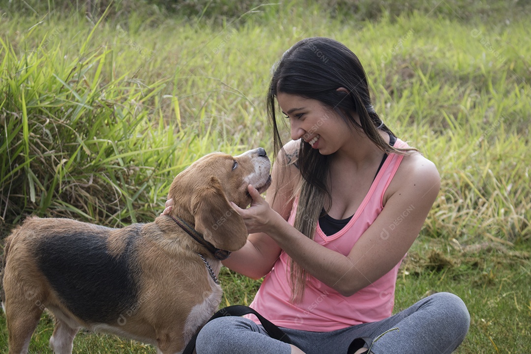 Adolescente morena com cachorro beagle no parque ao ar livre