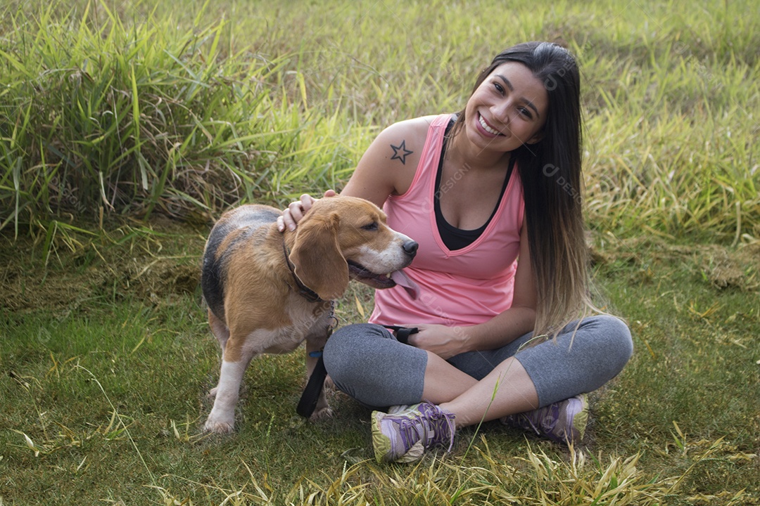 Adolescente morena com cachorro beagle no parque ao ar livre