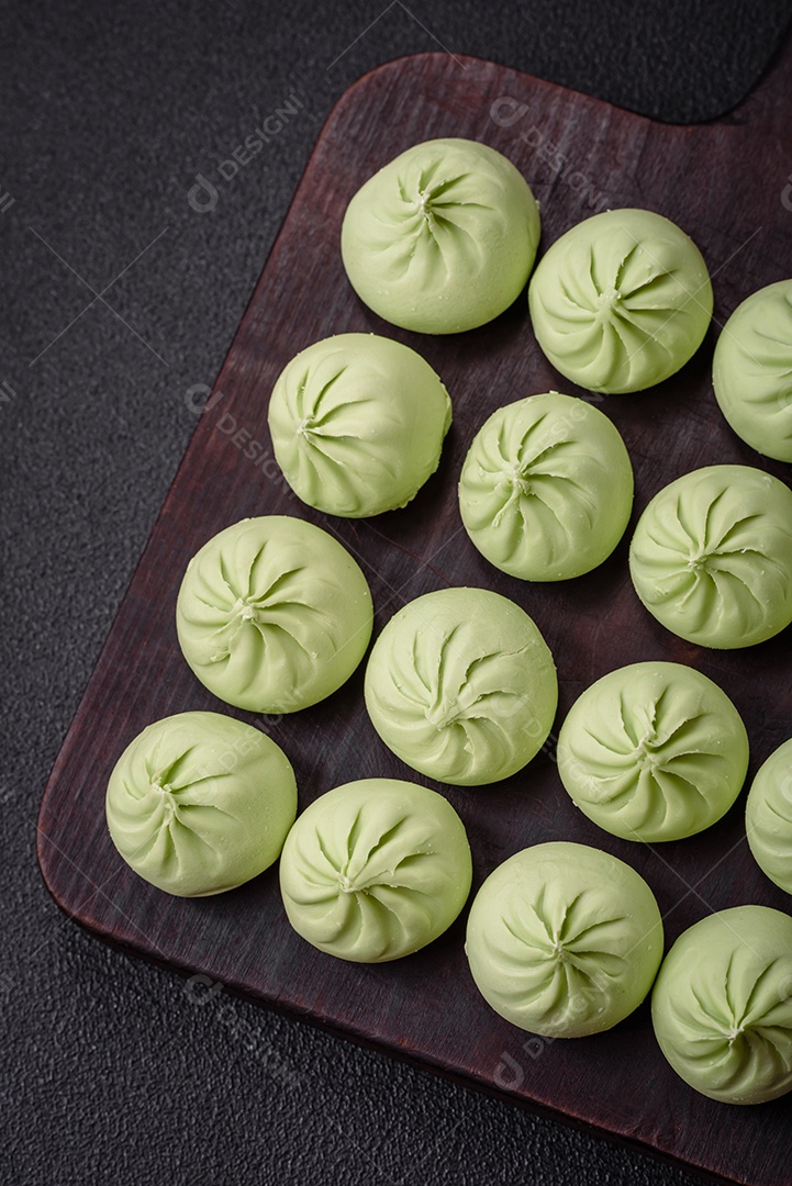 Khinkali cru ou bolinhos verdes com sal, especiarias e ervas sobre um fundo escuro de concreto