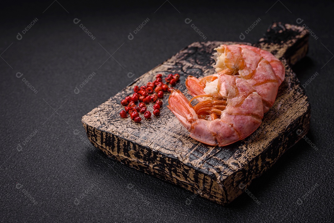 Deliciosas caudas de camarão ou lagostim fervidas com sal e especiarias sobre um fundo escuro de concreto