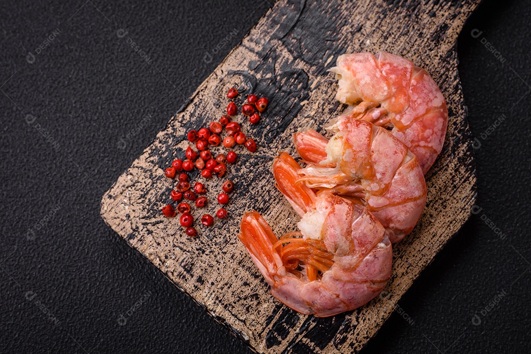 Deliciosas caudas de camarão ou lagostim fervidas com sal e especiarias sobre um fundo escuro de concreto