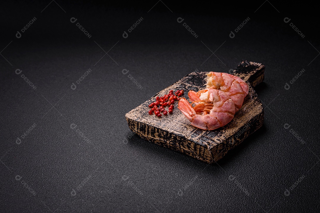 Deliciosas caudas de camarão ou lagostim fervidas com sal e especiarias sobre um fundo escuro de concreto