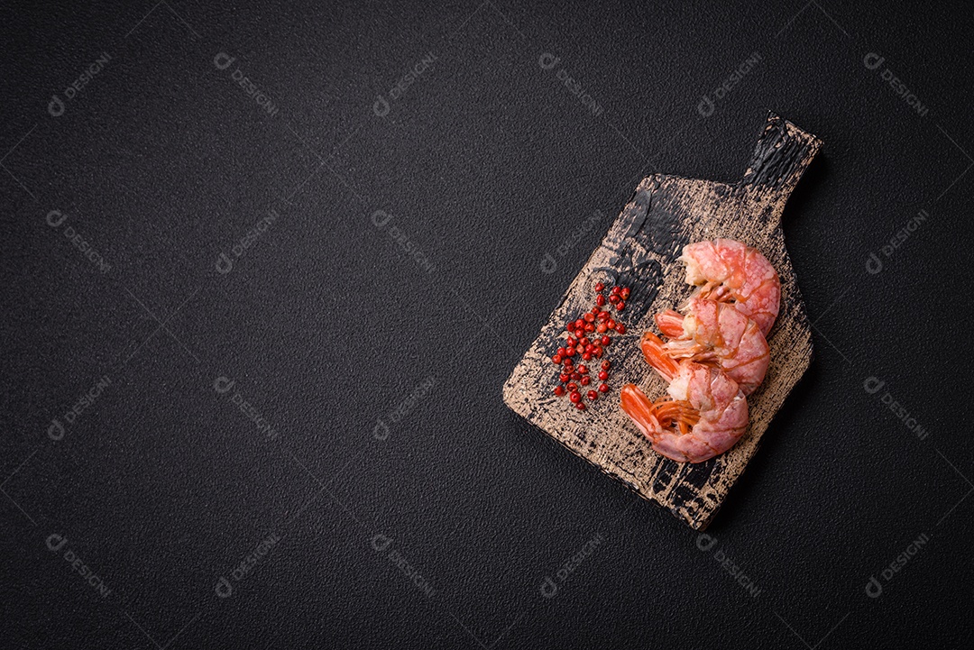 Deliciosas caudas de camarão ou lagostim fervidas com sal e especiarias sobre um fundo escuro de concreto