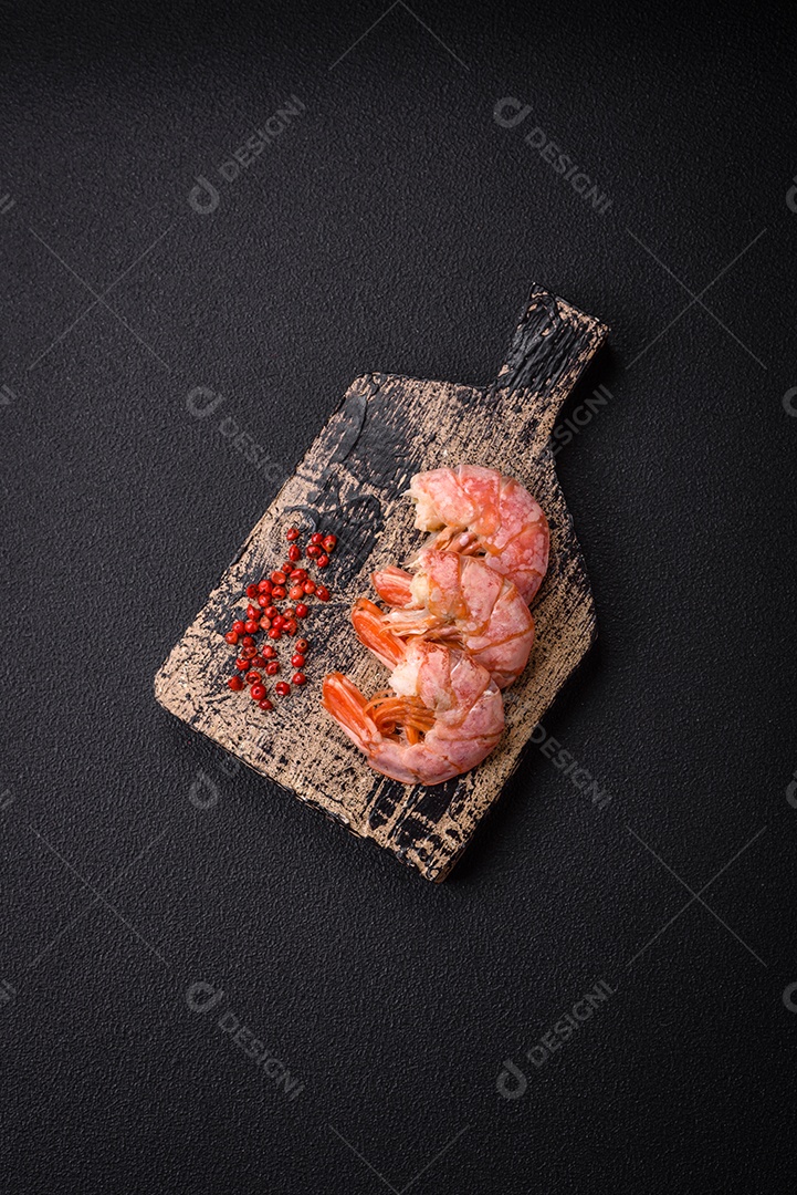 Deliciosas caudas de camarão ou lagostim fervidas com sal e especiarias sobre um fundo escuro de concreto