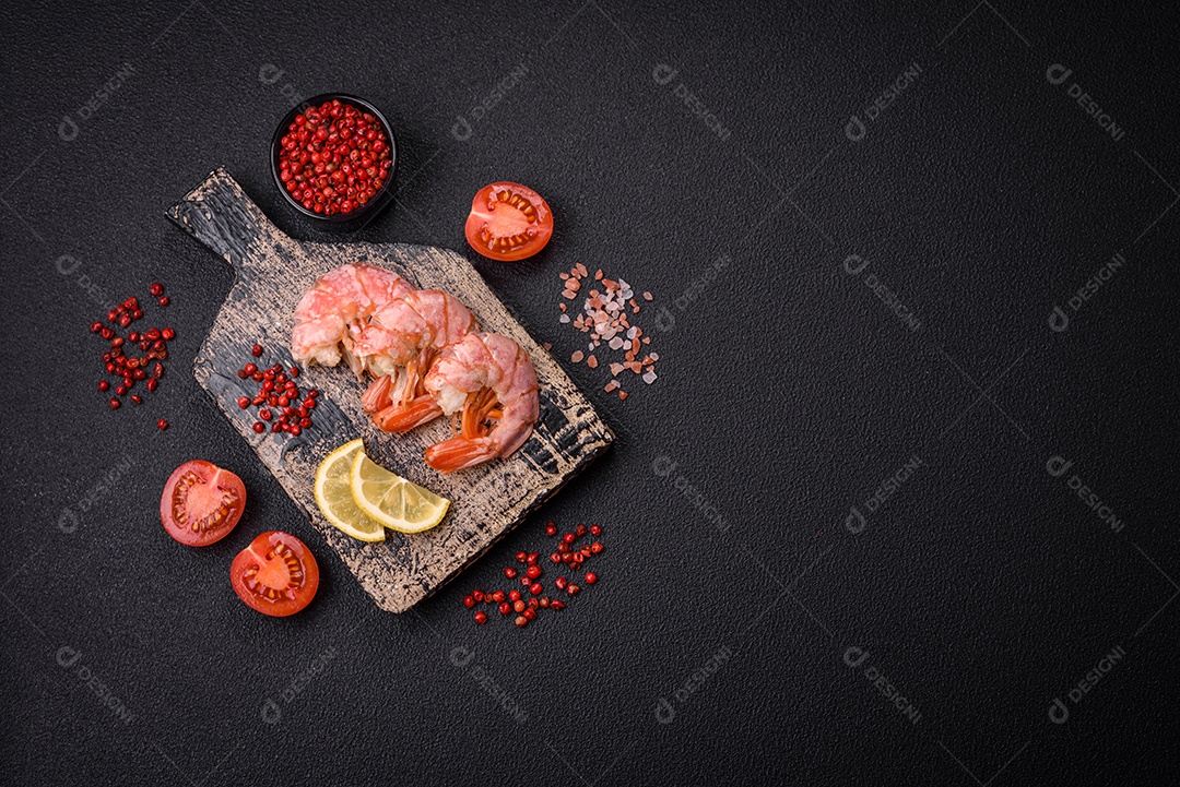 Deliciosas caudas de camarão ou lagostim fervidas com sal e especiarias sobre um fundo escuro de concreto