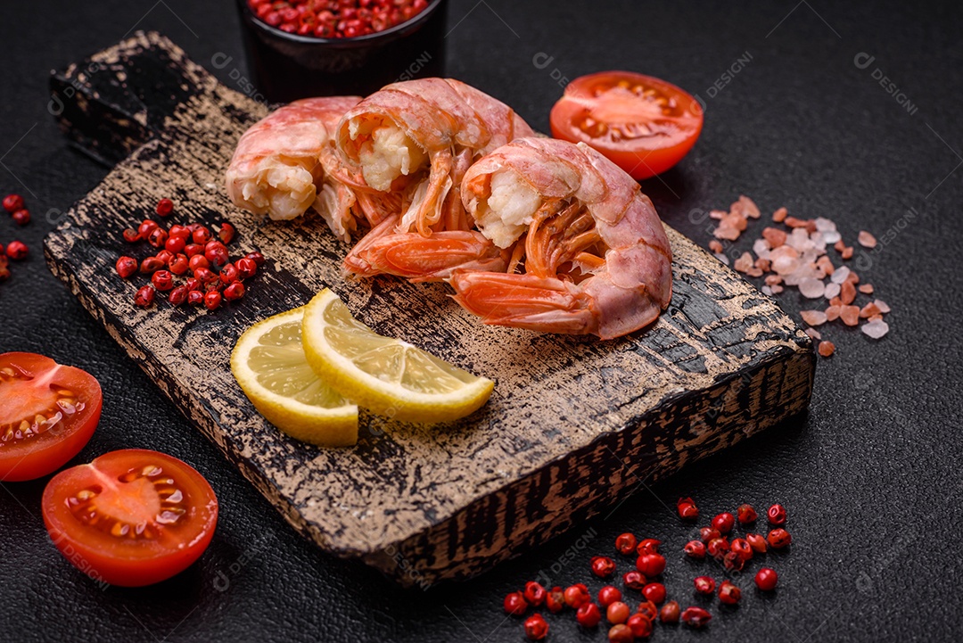 Deliciosas caudas de camarão ou lagostim fervidas com sal e especiarias sobre um fundo escuro de concreto