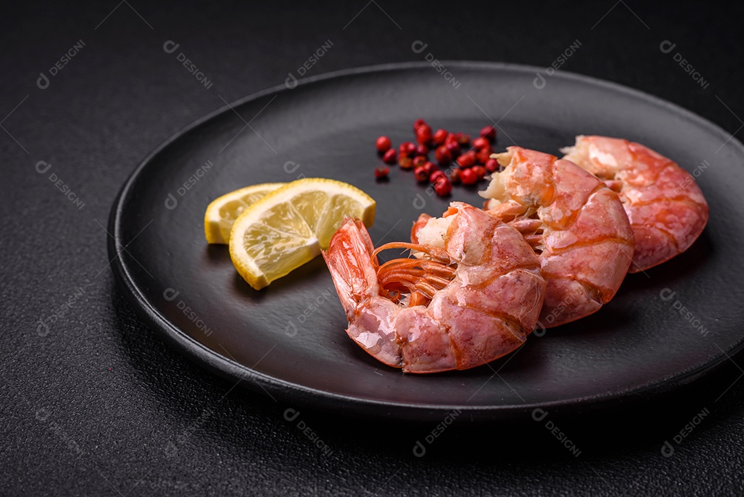 Deliciosas caudas de camarão ou lagostim fervidas com sal e especiarias sobre um fundo escuro de concreto