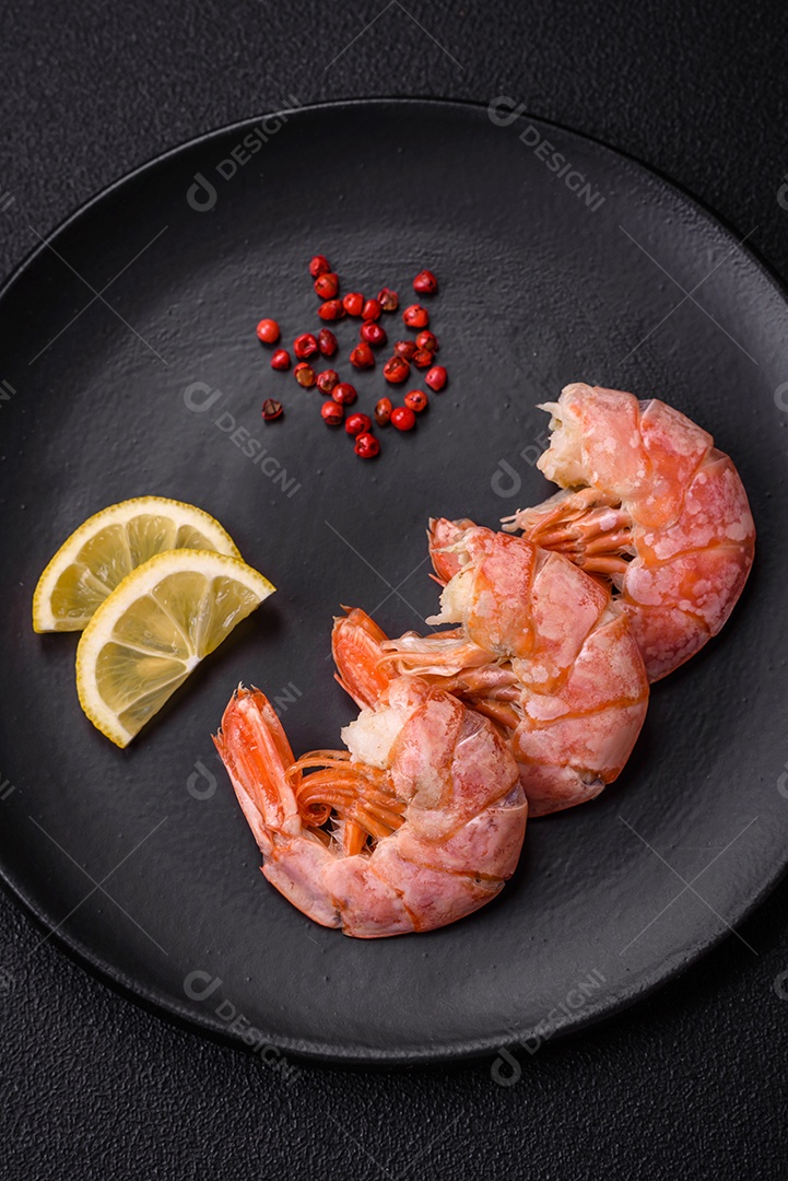 Deliciosas caudas de camarão ou lagostim fervidas com sal e especiarias sobre um fundo escuro de concreto