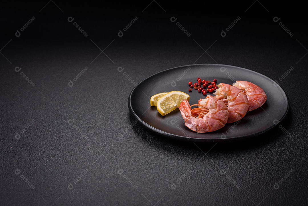 Deliciosas caudas de camarão ou lagostim fervidas com sal e especiarias sobre um fundo escuro de concreto