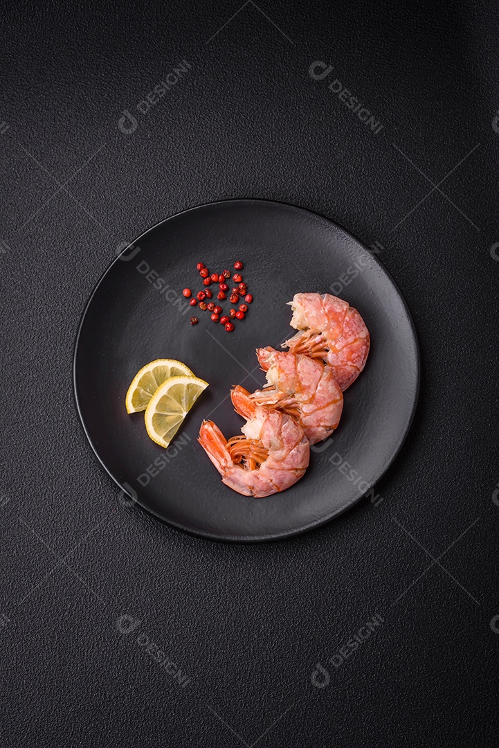 Deliciosas caudas de camarão ou lagostim fervidas com sal e especiarias sobre um fundo escuro de concreto