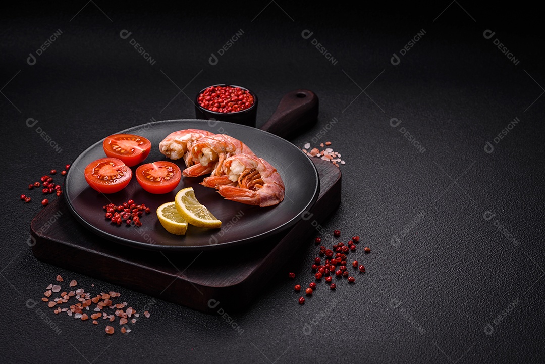 Deliciosas caudas de camarão ou lagostim fervidas com sal e especiarias sobre um fundo escuro de concreto