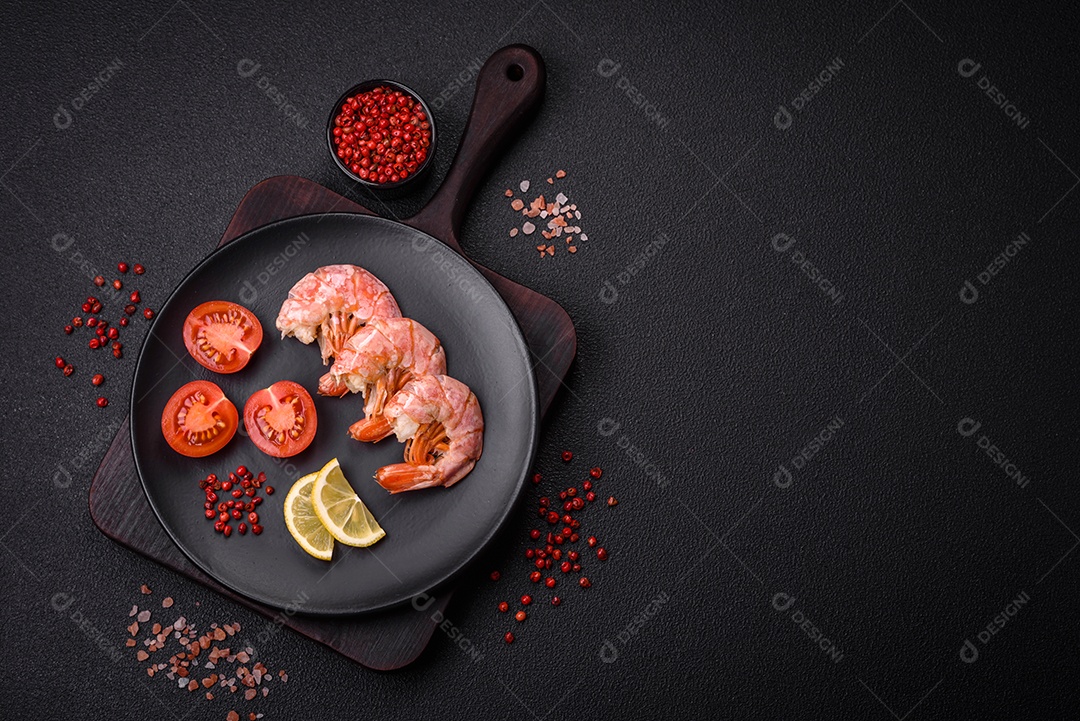 Deliciosas caudas de camarão ou lagostim fervidas com sal e especiarias sobre um fundo escuro de concreto