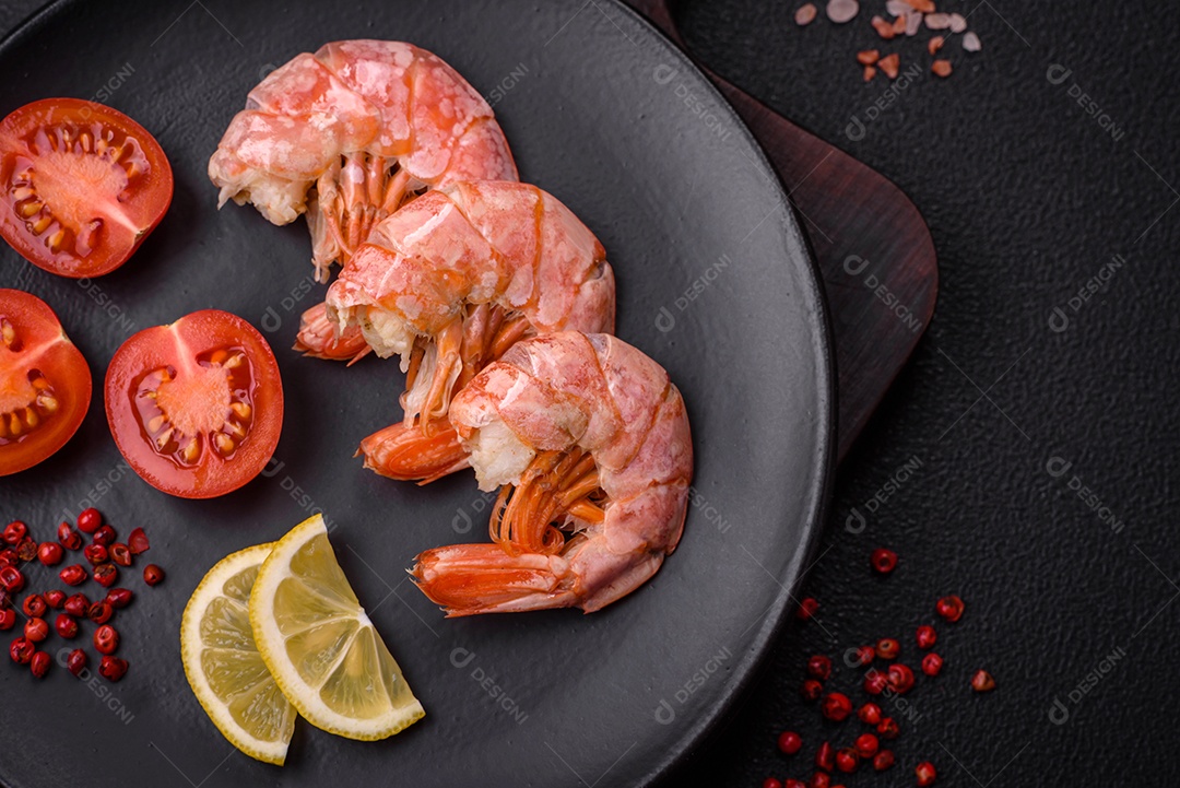 Deliciosas caudas de camarão ou lagostim fervidas com sal e especiarias sobre um fundo escuro de concreto