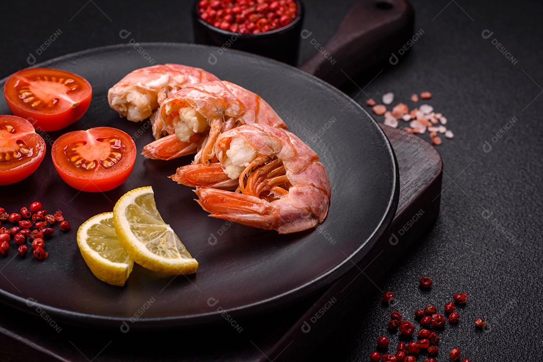 Deliciosas caudas de camarão ou lagostim fervidas com sal e especiarias sobre um fundo escuro de concreto