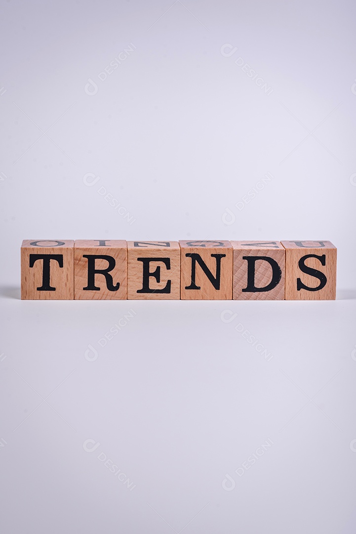 A inscrição Tendência feita de cubos de madeira sobre um fundo liso. Pode ser usado para o seu design