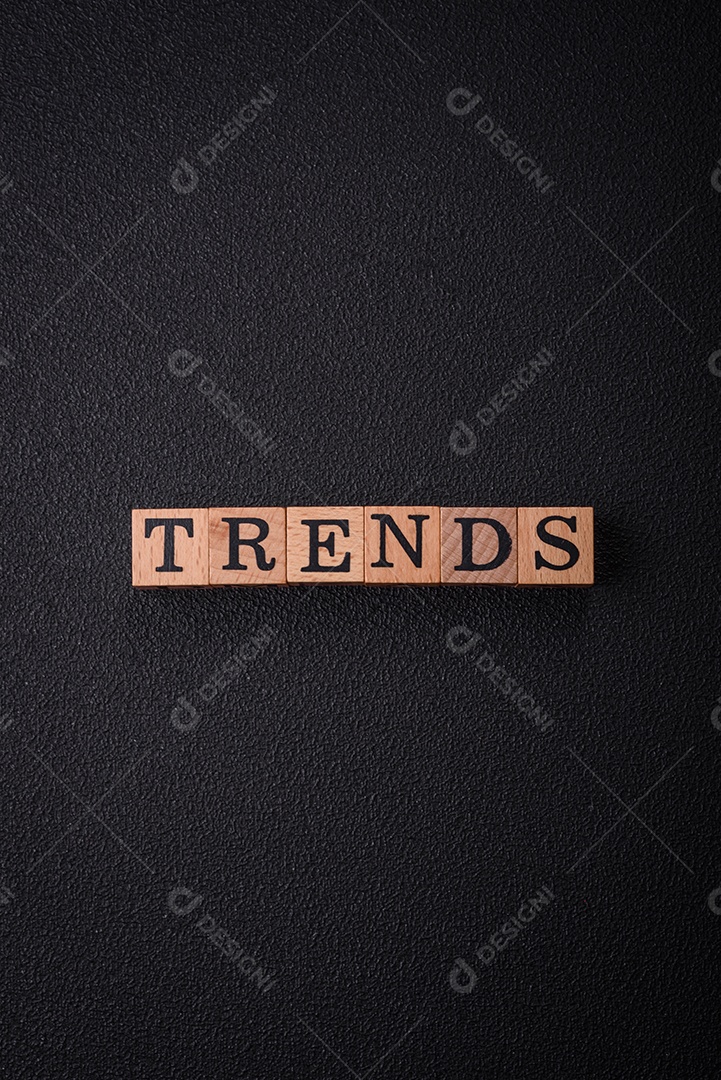 A inscrição Tendência feita de cubos de madeira sobre um fundo liso. Pode ser usado para o seu design