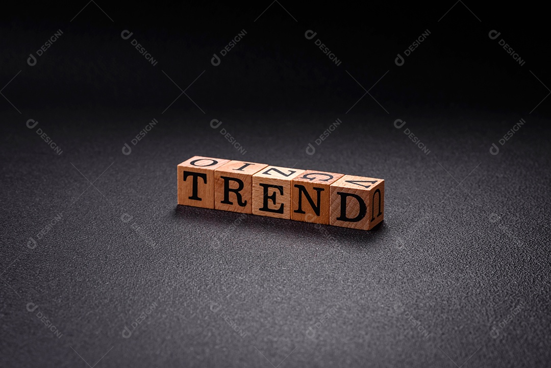 A inscrição Tendência feita de cubos de madeira sobre um fundo liso. Pode ser usado para o seu design