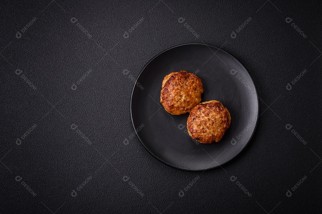 Deliciosas costeletas de peixe picado frito fresco com especiarias e ervas sobre um fundo escuro de concreto