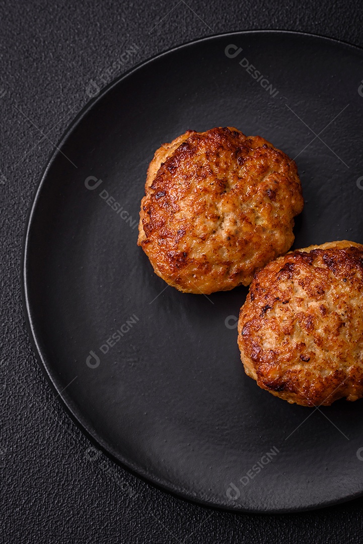 Deliciosas costeletas de peixe picado frito fresco com especiarias e ervas sobre um fundo escuro de concreto