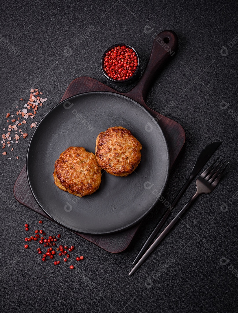 Deliciosas costeletas de peixe picado frito fresco com especiarias e ervas sobre um fundo escuro de concreto