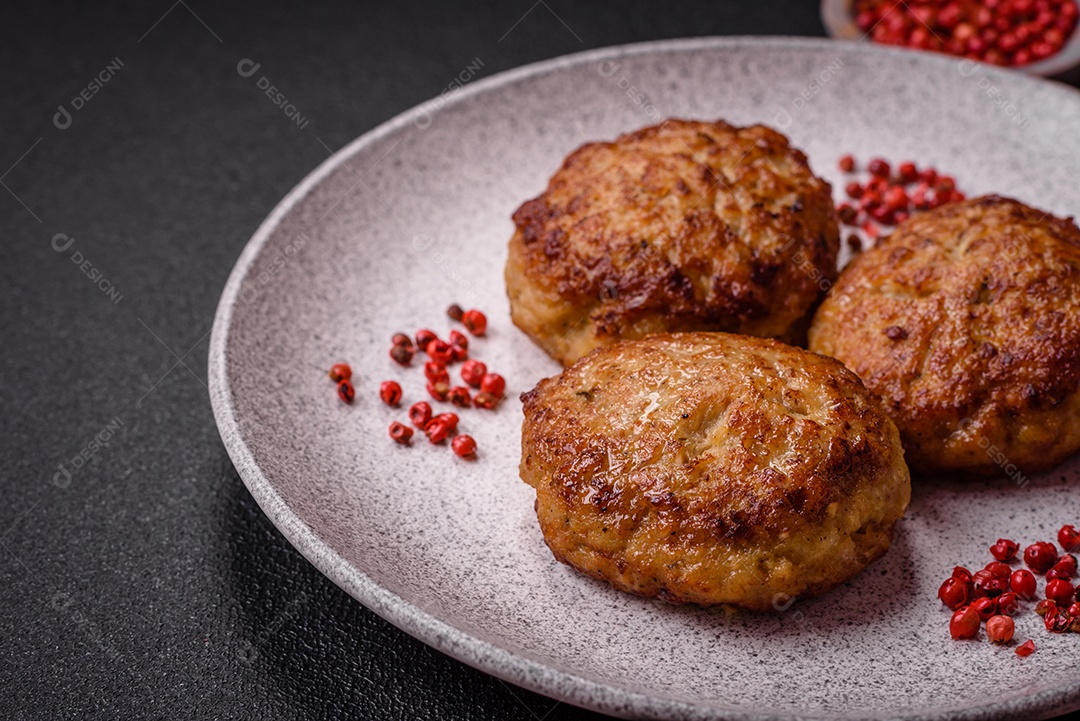 Deliciosas costeletas de peixe picado frito fresco com especiarias e ervas sobre um fundo escuro de concreto