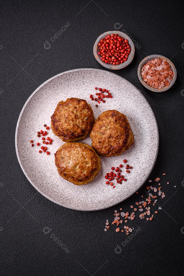 Deliciosas costeletas de peixe picado frito fresco com especiarias e ervas sobre um fundo escuro de concreto