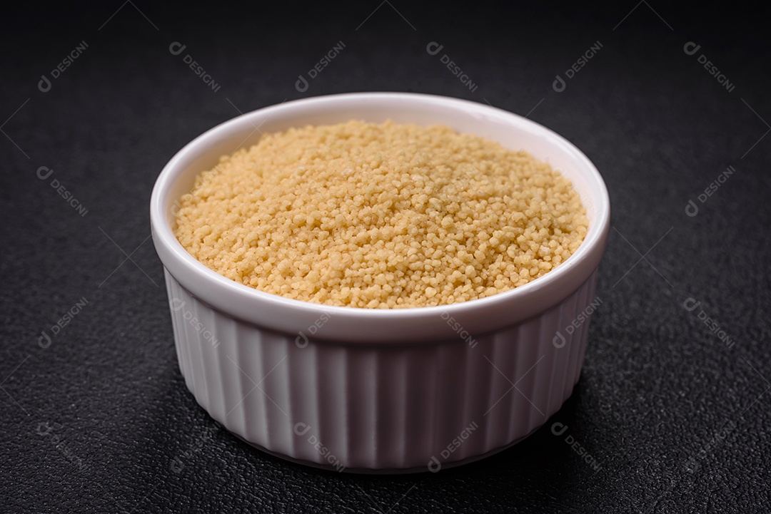 Grãos de mingau de trigo Ptitim em um fundo escuro de concreto. Preparando um café da manhã delicioso e nutritivo