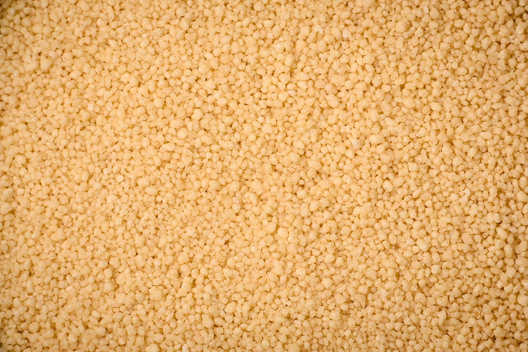 Grãos de mingau de trigo Ptitim em um fundo escuro de concreto. Preparando um café da manhã delicioso e nutritivo