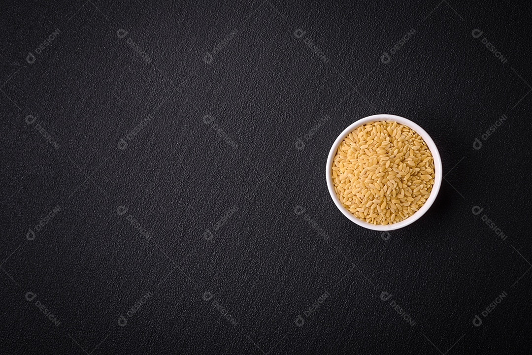 Grãos de mingau de trigo Ptitim em um fundo escuro de concreto. Preparando um café da manhã delicioso e nutritivo