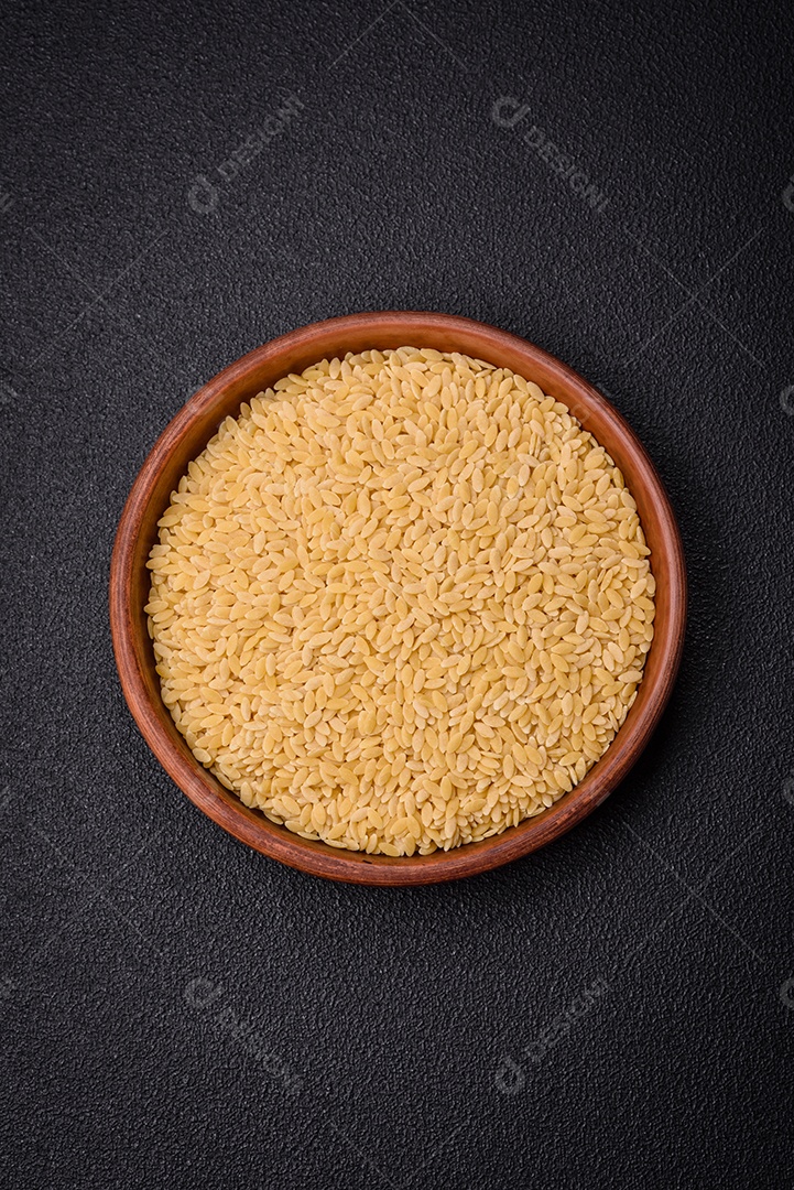 Grãos de mingau de trigo Ptitim em um fundo escuro de concreto. Preparando um café da manhã delicioso e nutritivo