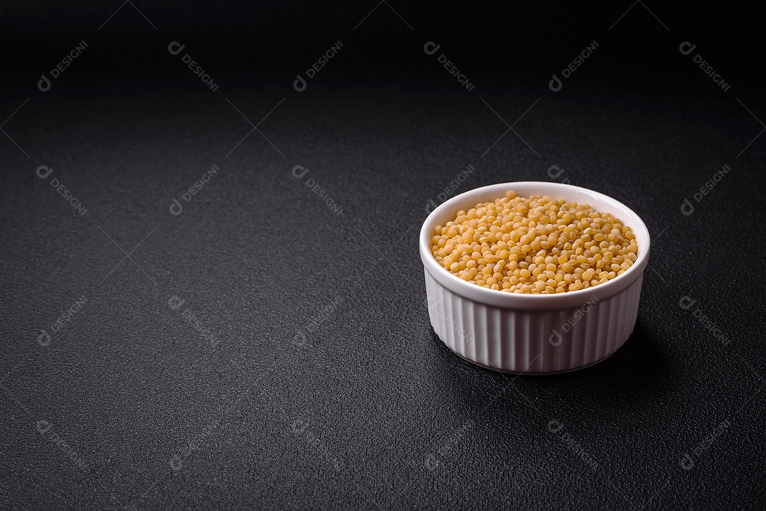 Grãos de mingau de trigo Ptitim em um fundo escuro de concreto. Preparando um café da manhã delicioso e nutritivo