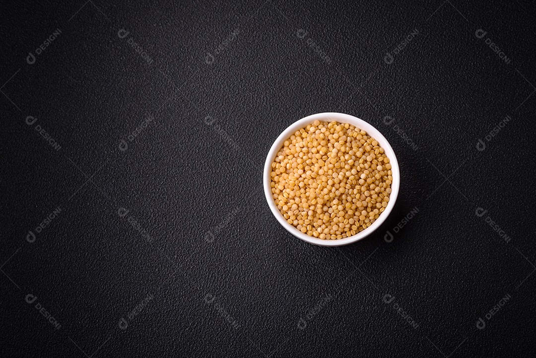 Grãos de mingau de trigo Ptitim em um fundo escuro de concreto. Preparando um café da manhã delicioso e nutritivo