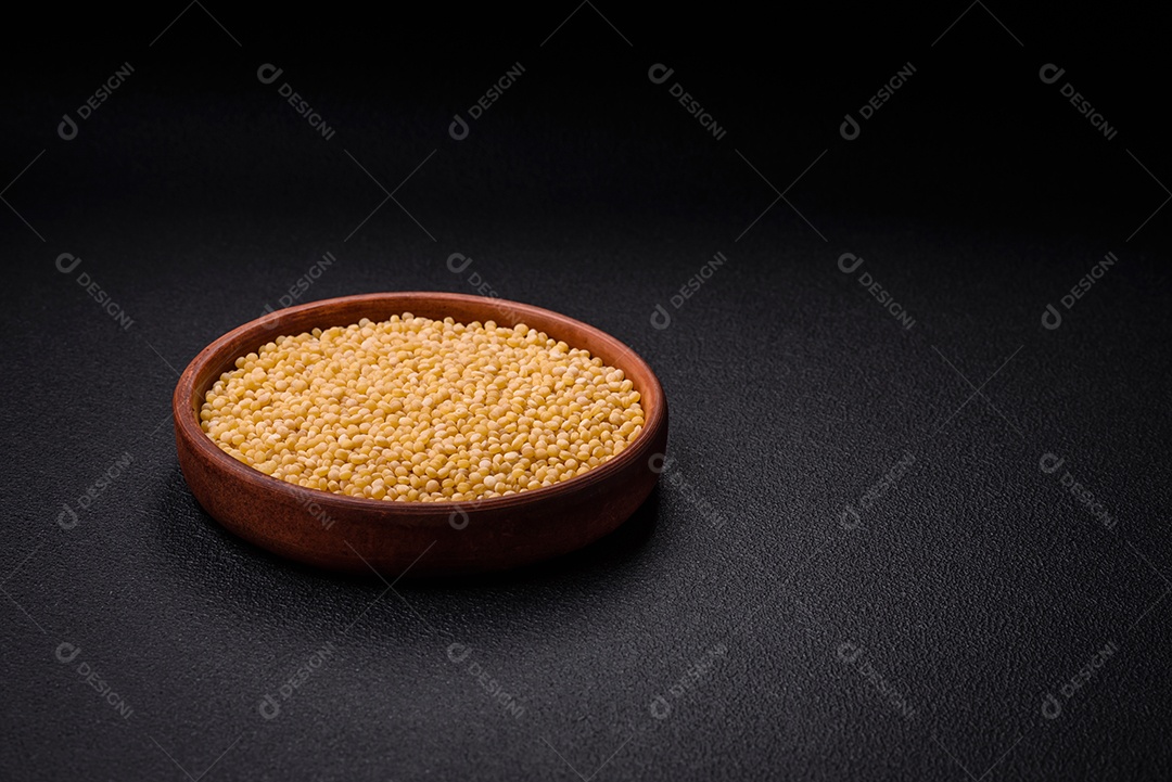 Grãos de mingau de trigo Ptitim em um fundo escuro de concreto. Preparando um café da manhã delicioso e nutritivo