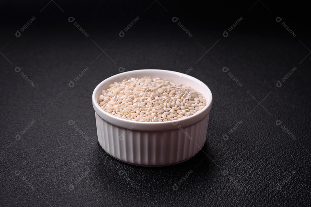 Grandes grãos de arroz branco cru em uma tigela de cerâmica. Cozinhando um delicioso mingau nutritivo