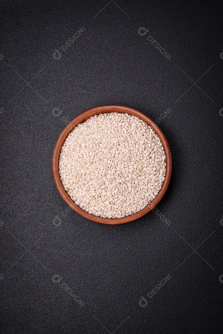 Grandes grãos de arroz branco cru em uma tigela de cerâmica. Cozinhando um delicioso mingau nutritivo