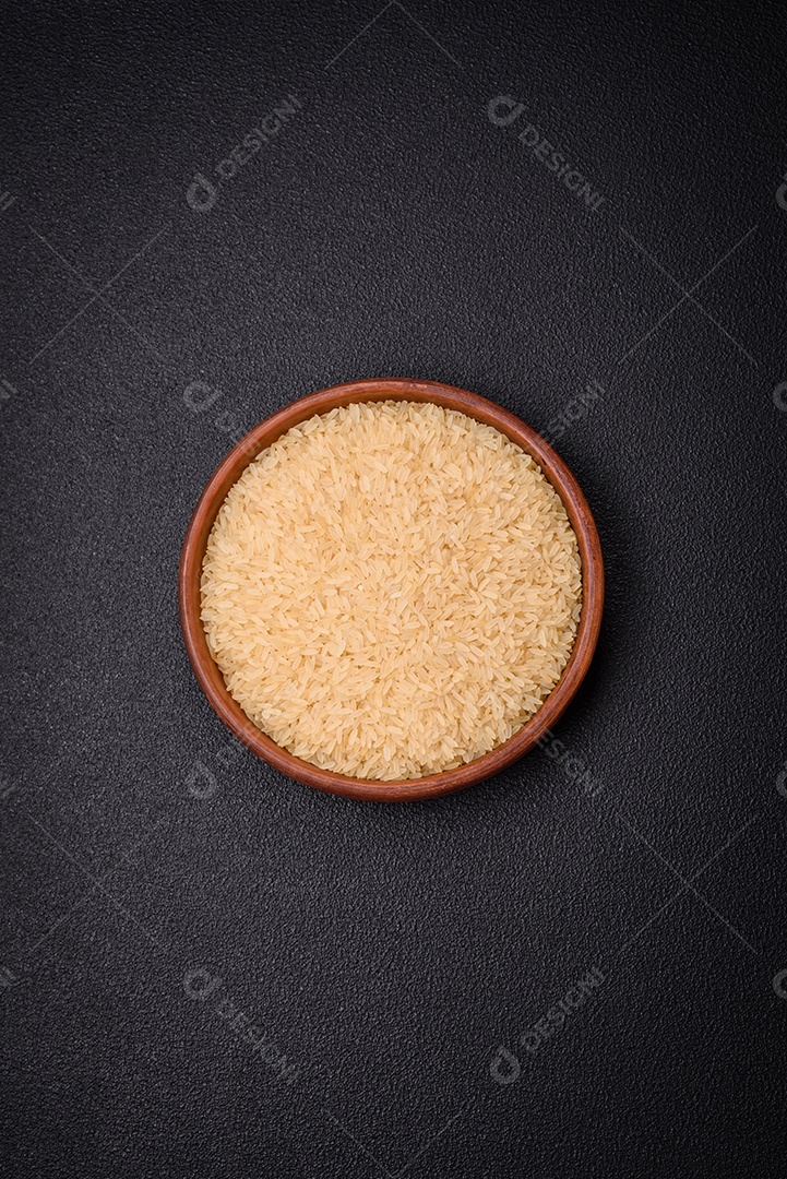 Grandes grãos de arroz branco cru em uma tigela de cerâmica. Cozinhando um delicioso mingau nutritivo