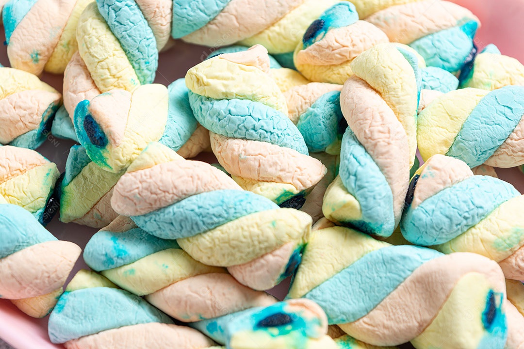 Deliciosos marshmallows em recipiente colorido.