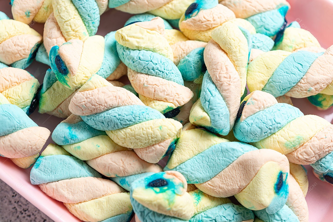 Deliciosos marshmallows em recipiente colorido.