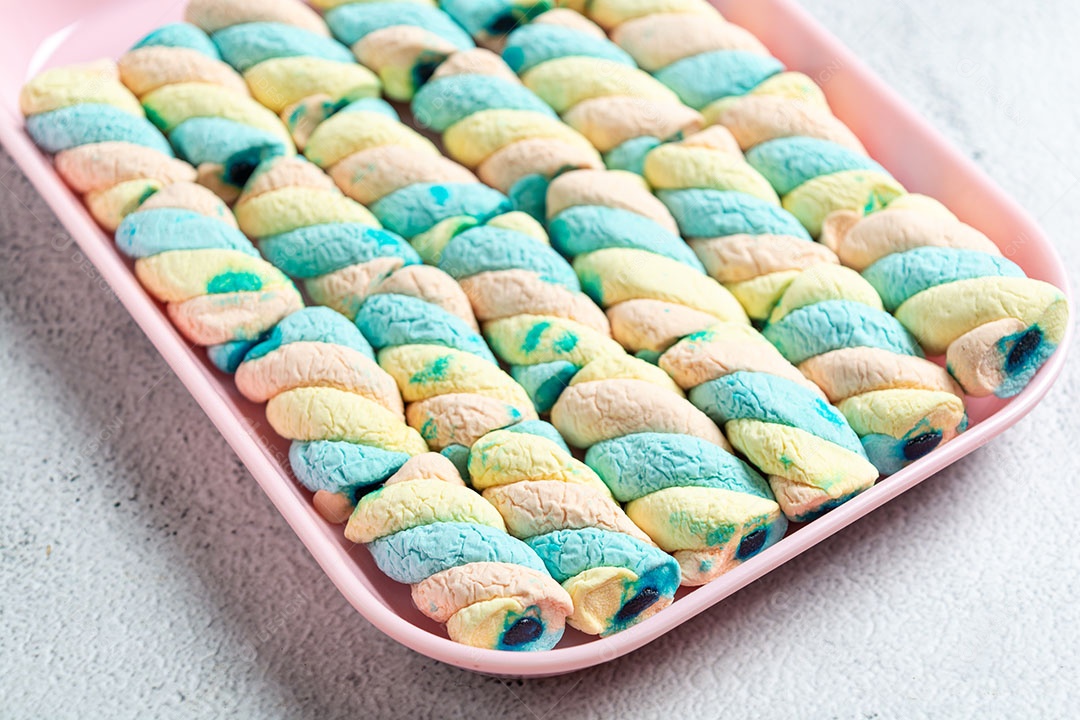 Deliciosos marshmallows em recipiente colorido.