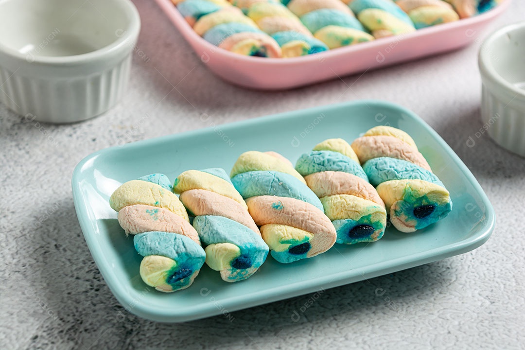 Deliciosos marshmallows em recipiente colorido.