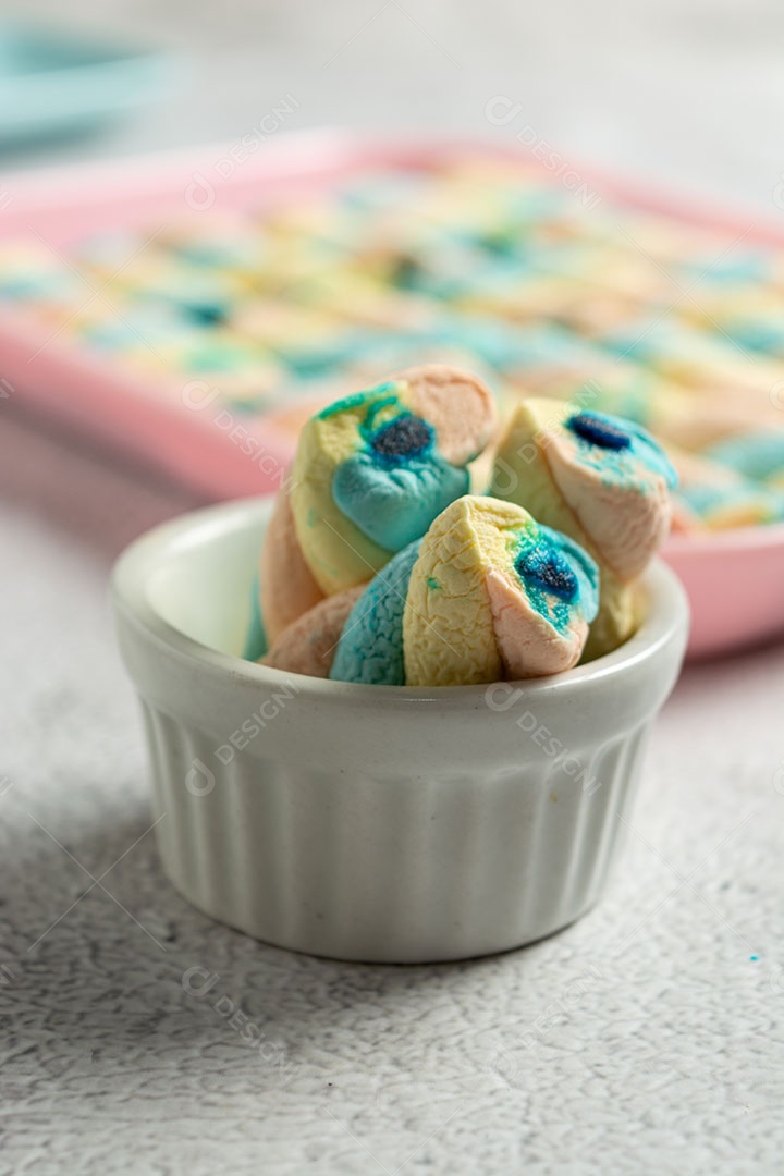 Deliciosos marshmallows em recipiente branco sobre fundo desfocado..