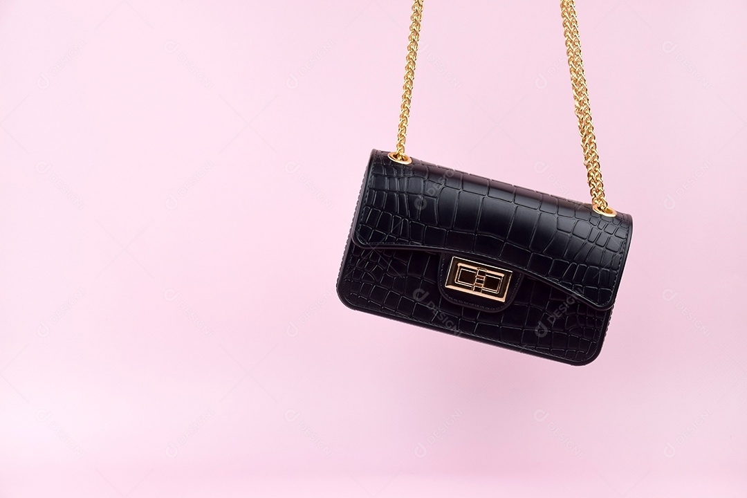 Bolsa feminina negra sobre fundo rosa