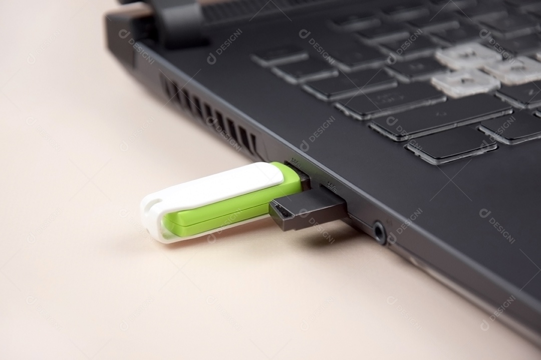 Cartão de memória USB branco verde no teclado de um laptop aberto