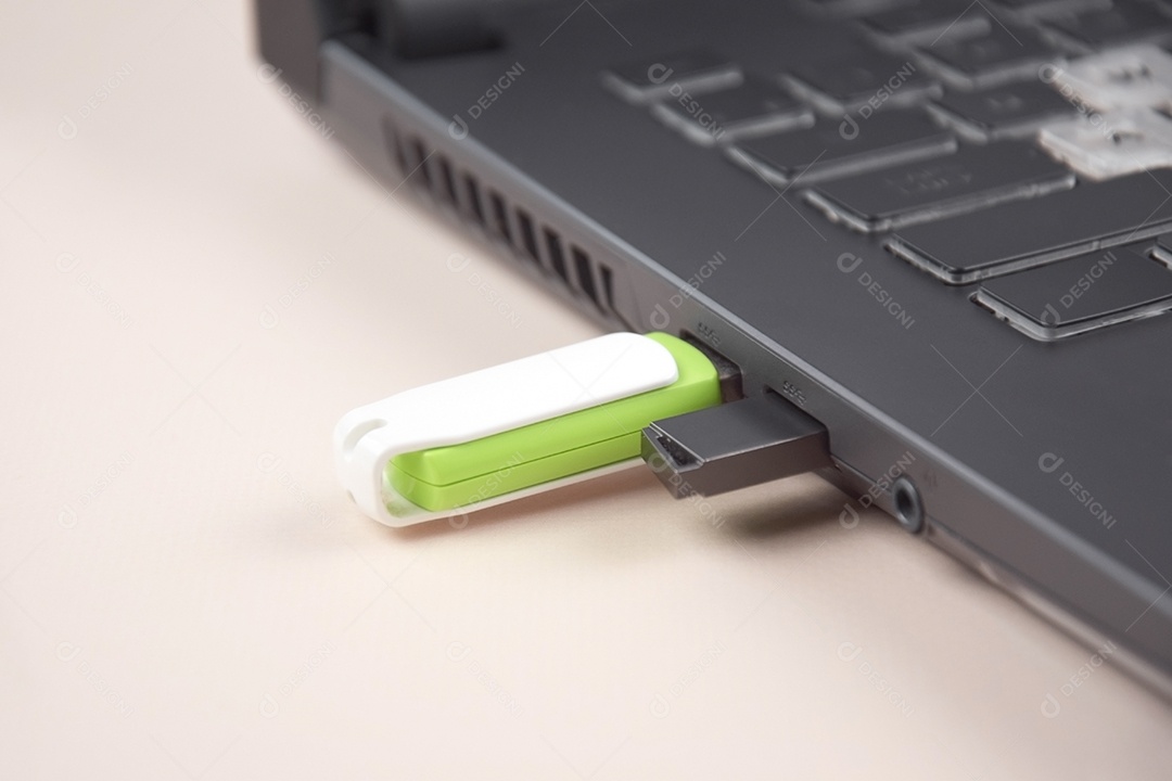 Cartão de memória USB branco verde no teclado de um laptop aberto