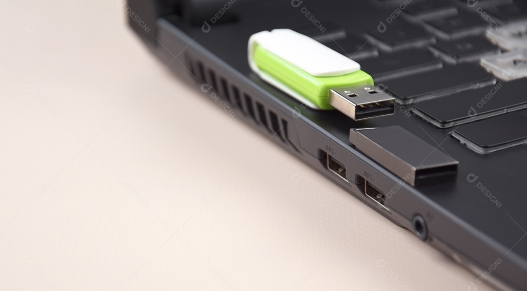 Cartão de memória USB branco verde no teclado de um laptop aberto