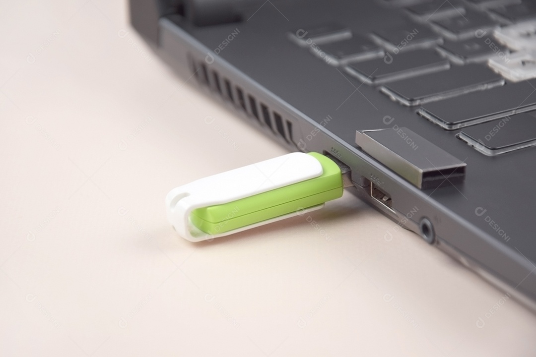 Cartão de memória USB branco verde no teclado de um laptop aberto