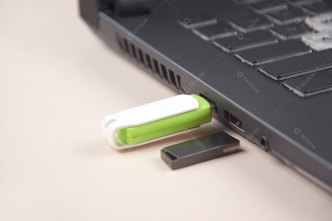 Cartão de memória USB branco verde no teclado de um laptop aberto