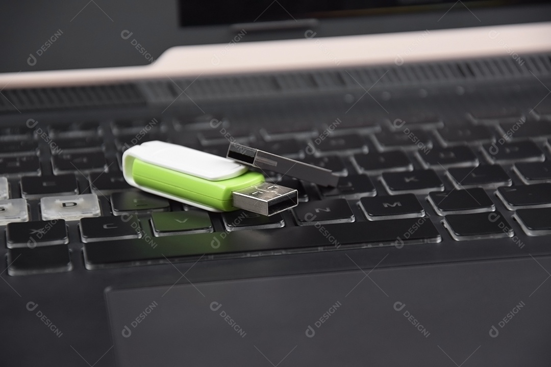 Cartão de memória USB branco verde ou unidade flash no teclado de um laptop aberto