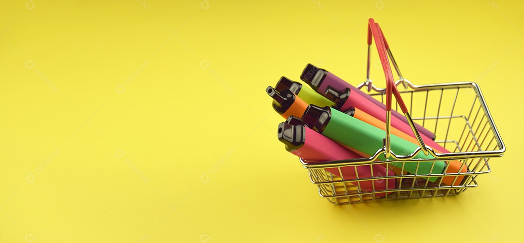 Cesta de compra com cigarros eletrônicos dentro conceito de comprar em fundo amarelo