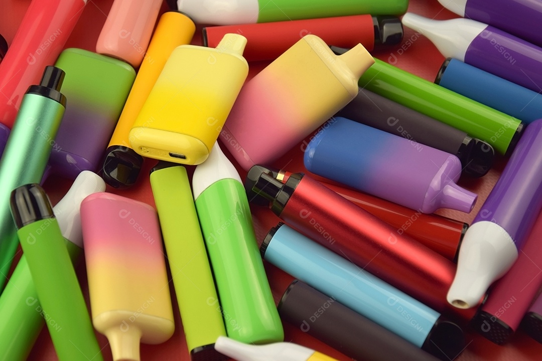 Cigarros eletrônico coloridos sobre fundo vermelho